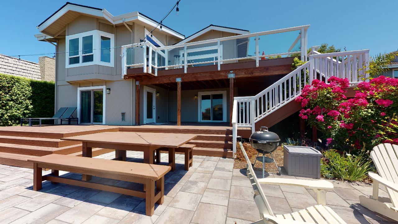 150 Vía Soderini Aptos, CA 95003 - Photo 60 of 73 a view of a white house with a large pool lawn chairs and a yard