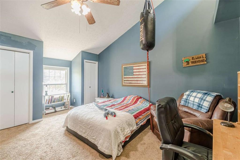 2229 South Van Wert Road Villa Rica, GA 30180 - Photo 31 of 92 a bedroom with a bed next to a window and a chandelier