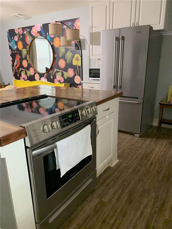2229 South Van Wert Road Villa Rica, GA 30180 - Photo 51 of 92 a kitchen with stainless steel appliances granite countertop a stove a refrigerator and a wooden floor