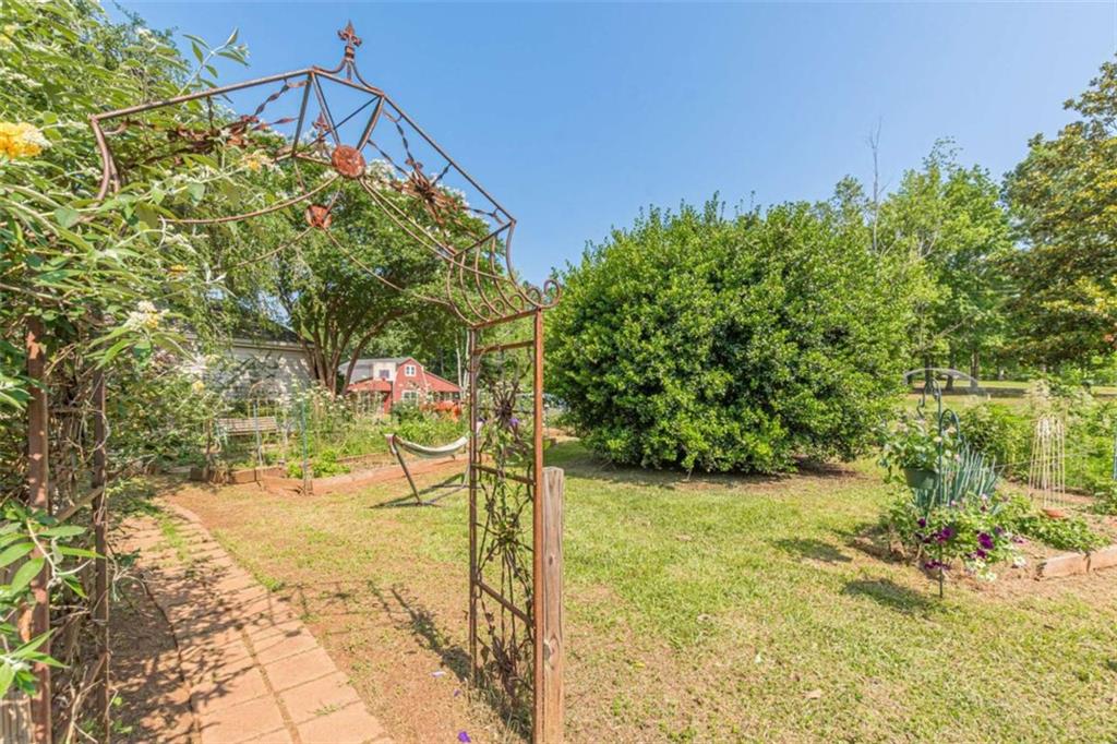 2229 South Van Wert Road Villa Rica, GA 30180 - Photo 69 of 92 a backyard of a house with large trees and plants