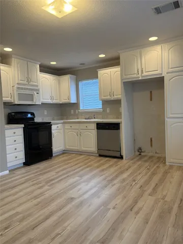 a kitchen with stainless steel appliances granite countertop a sink dishwasher a stove and a refrigerator