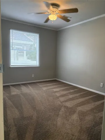 an empty room with windows and chandelier fan