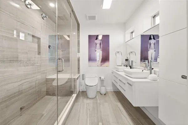 a bathroom with a sink mirror and toilet