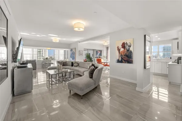 a living room with furniture and a view of kitchen