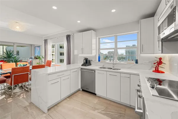 a kitchen that has a lot of cabinets in it and wooden floor