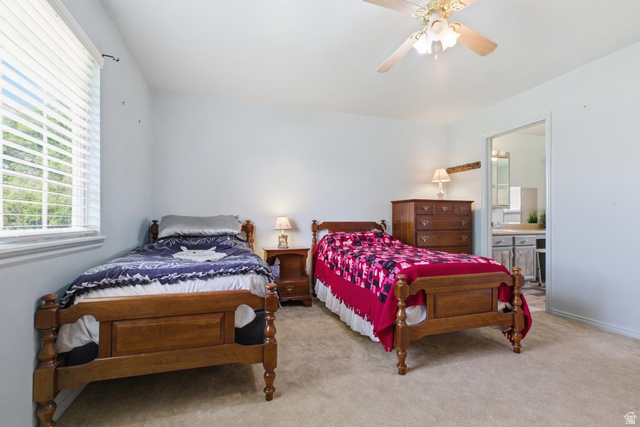 435 East 4th North Preston, ID 83263 - Photo 10 of 26 Carpeted room with a ceiling fan, a window with blinds, and an open doorway revealing a vanity with a sink