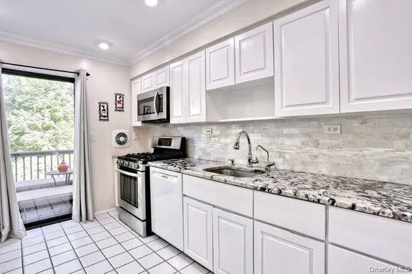 a kitchen with granite countertop white cabinets and white appliances