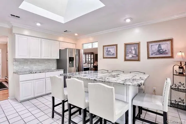 a kitchen with stainless steel appliances granite countertop a stove a sink a dining table and chairs
