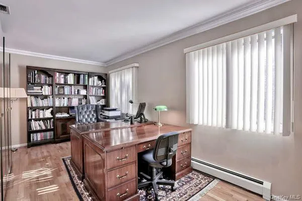 a view of a workspace with furniture and a window