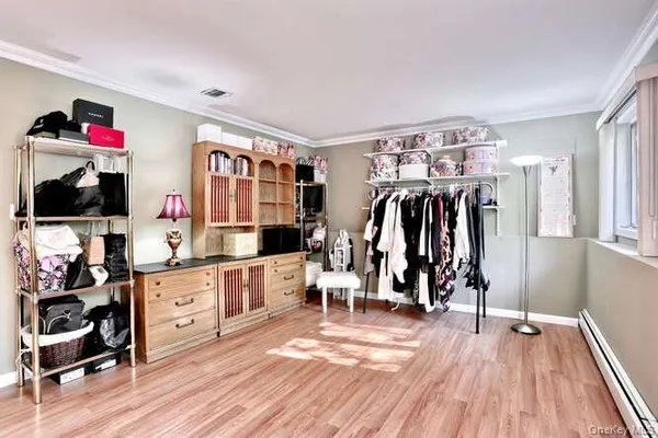 a view of a living room with clothes and a hard wood floor