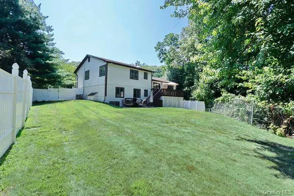 a view of a house with a big yard and large trees