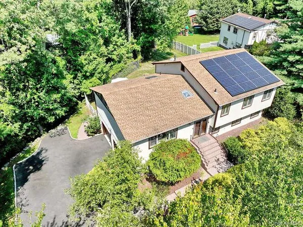 an aerial view of a house with yard and patio