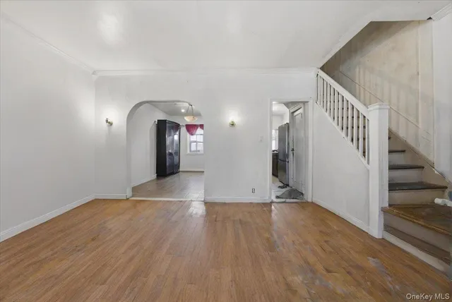 a view of a livingroom with wooden floor and stairs