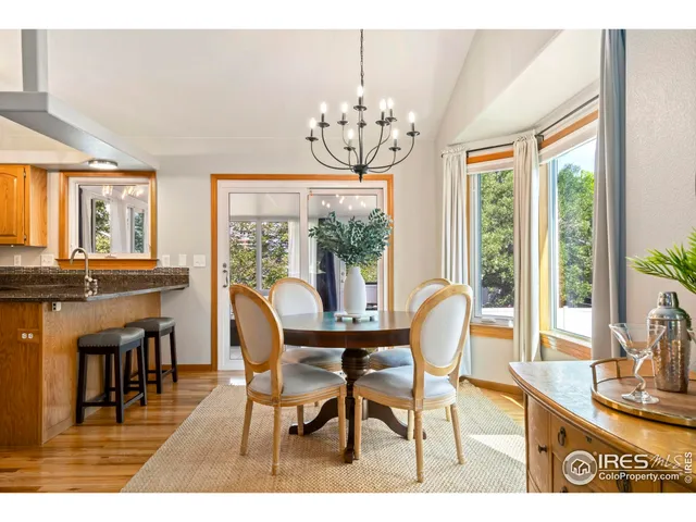a dining room with furniture a chandelier and wooden floor