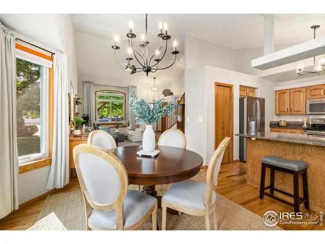 a dining room with furniture a livingroom view and wooden floor