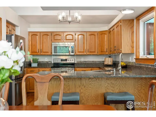 a kitchen with stainless steel appliances granite countertop a sink a stove cabinets and dining table