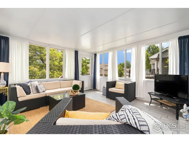 a living room with furniture a flat screen tv and a large window