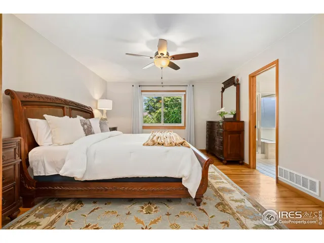a bedroom with a bed chandelier and a window