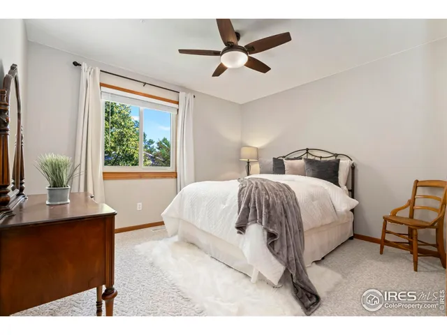 a bedroom with a bed a window and a chandelier