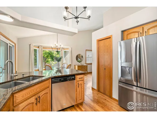 a kitchen with stainless steel appliances granite countertop a sink and a refrigerator
