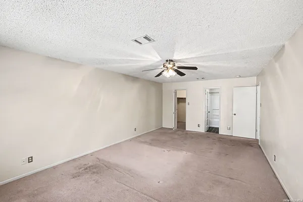 a view of an empty room with a chandelier fan