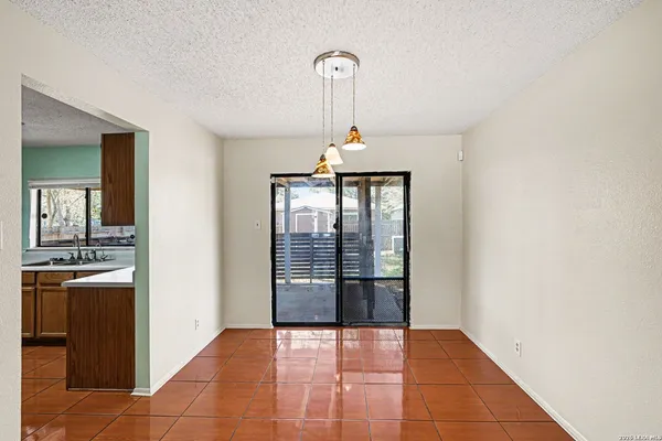 a view of a kitchen with granite countertop a refrigerator and a stove top oven