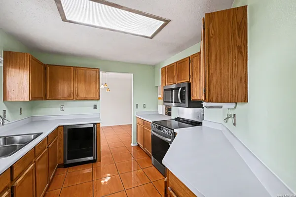 a kitchen with stainless steel appliances granite countertop a stove a sink and a microwave