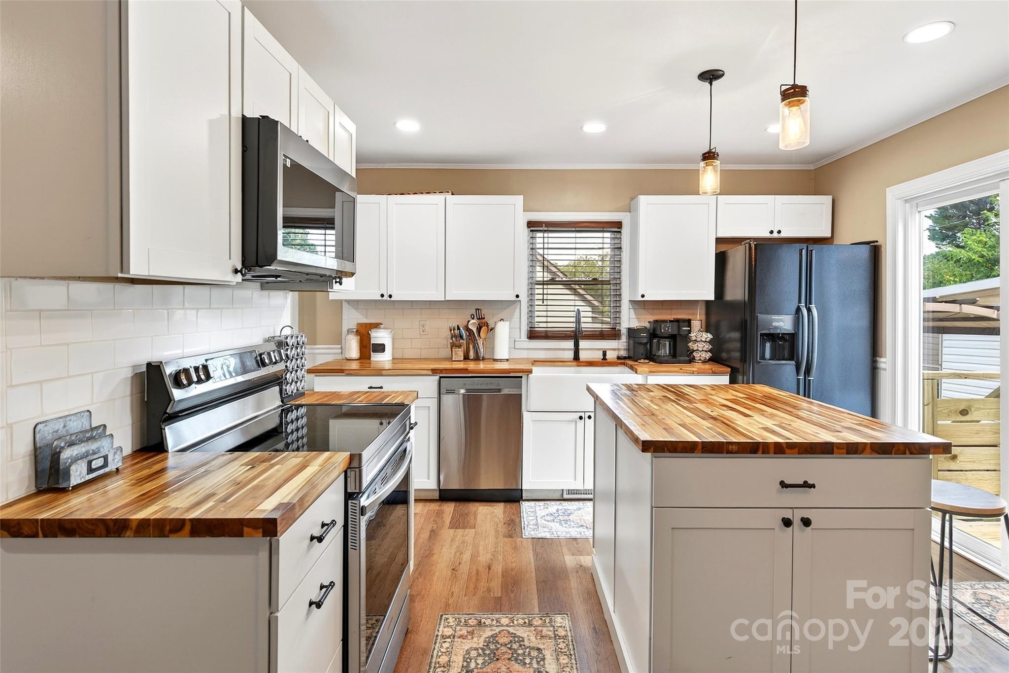 87 2nd Street Marion, NC 28752 - Photo 9 of 31 a kitchen with granite countertop kitchen island stainless steel appliances a sink a counter top space cabinets and a window