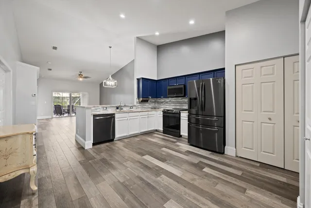 a kitchen with stainless steel appliances granite countertop a refrigerator oven a sink dishwasher and a stove with wooden floor