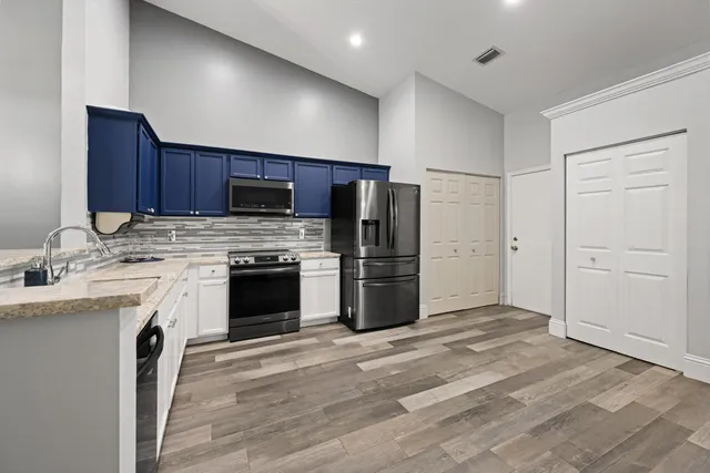 a kitchen with granite countertop wooden cabinets and stainless steel appliances