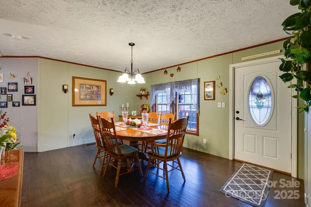 a dining room with furniture a chandelier and wooden floor