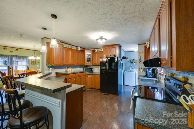 a kitchen with stainless steel appliances granite countertop a stove a sink and a microwave