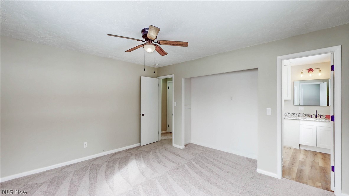 3312 Bancroft Road Akron, OH 44333 - Photo 30 of 50 Unfurnished bedroom featuring light colored carpet, ceiling fan, and ensuite bath