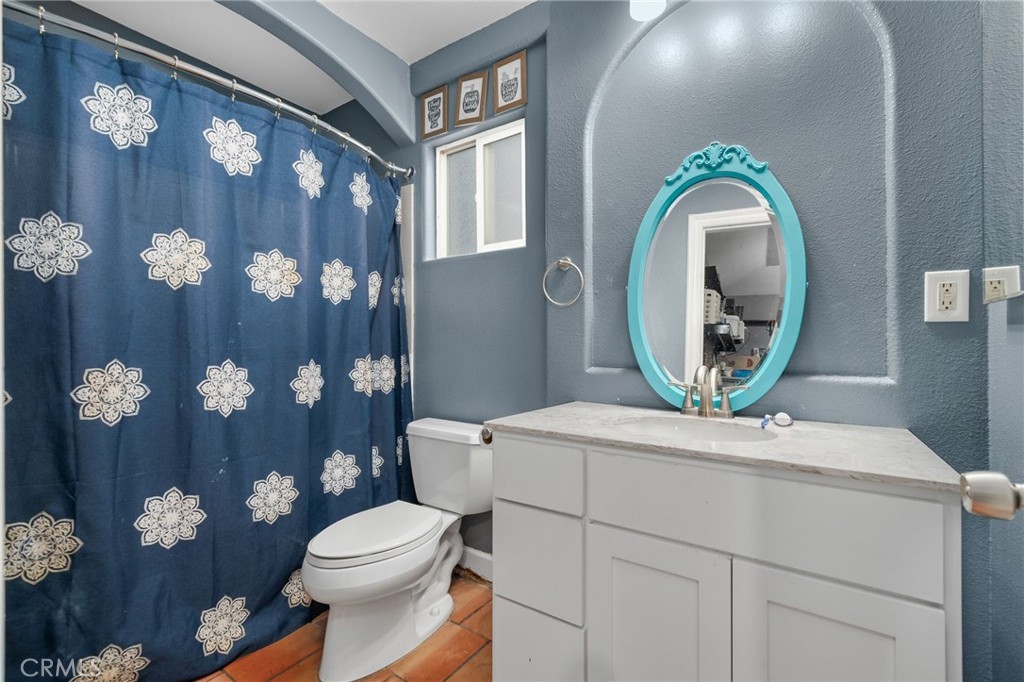 8538 Trey Avenue Riverside, CA 92503 - Photo 17 of 25 a bathroom with a toilet a sink and a mirror