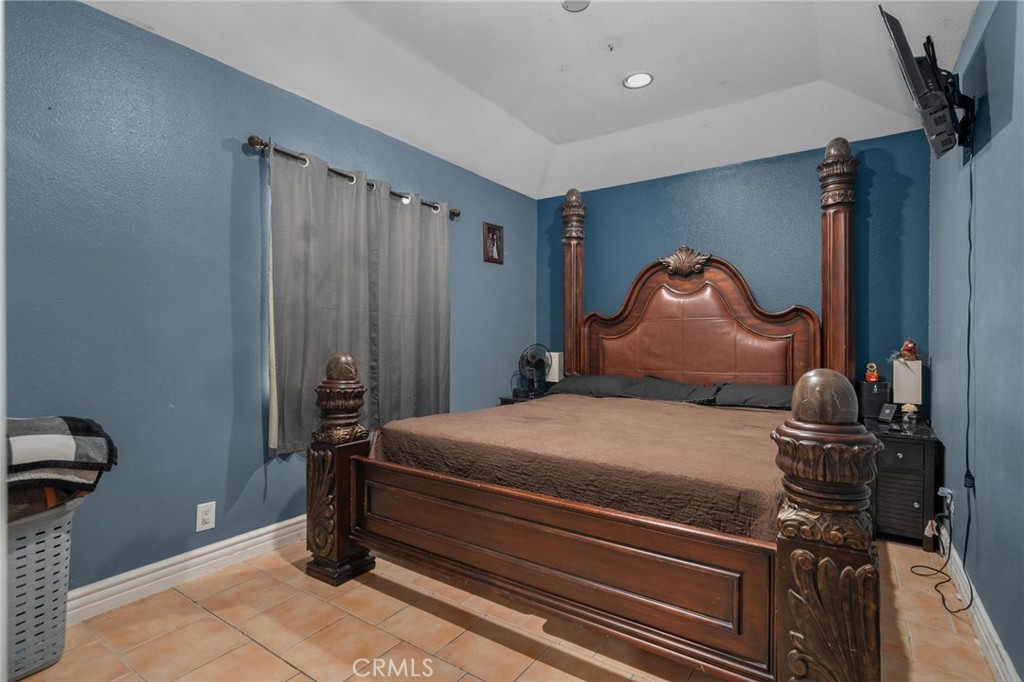 8538 Trey Avenue Riverside, CA 92503 - Photo 9 of 25 a bedroom with a bed and a chandelier