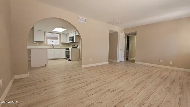 a view of a kitchen with a sink and dishwasher with wooden floor