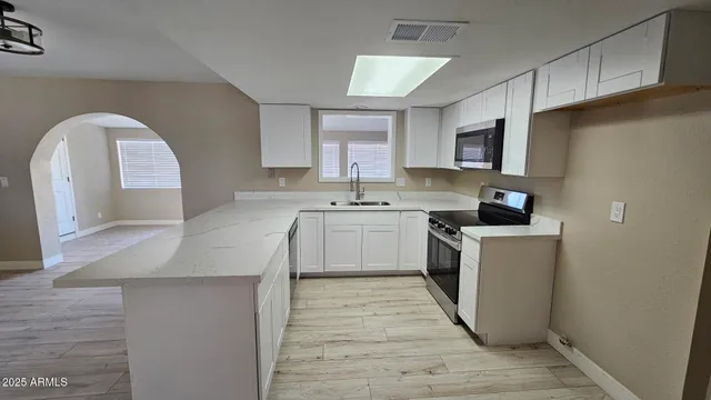 a kitchen with stainless steel appliances granite countertop a stove a sink and a microwave