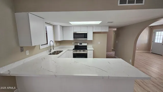 a kitchen with granite countertop a sink and a stove top oven