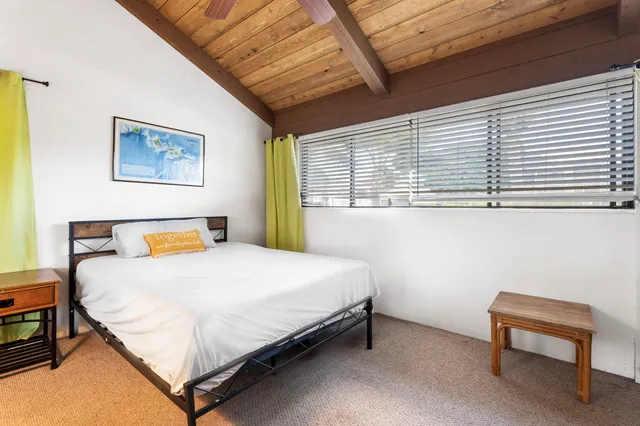 a bedroom with a bed and a potted plant