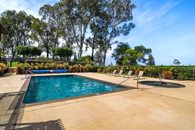 a view of a swimming pool with a patio and a yard