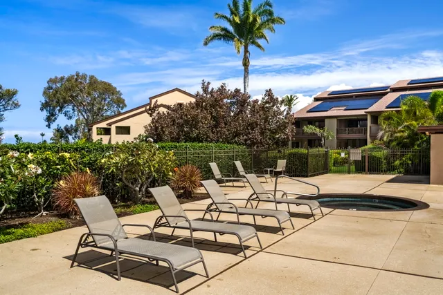 a view of a patio with table and chairs under an umbrella with potted plants