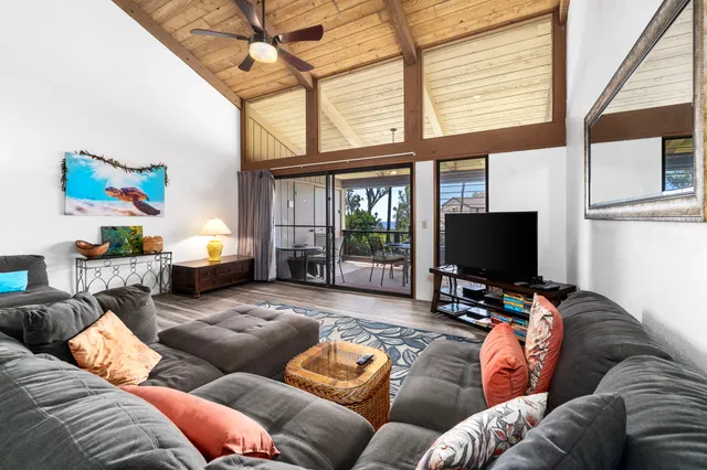 a living room with furniture a flat screen tv and a large window