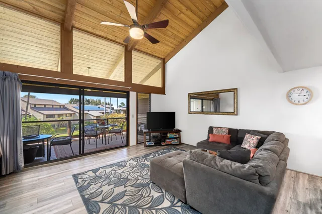 a living room with furniture a flat screen tv and a floor to ceiling window