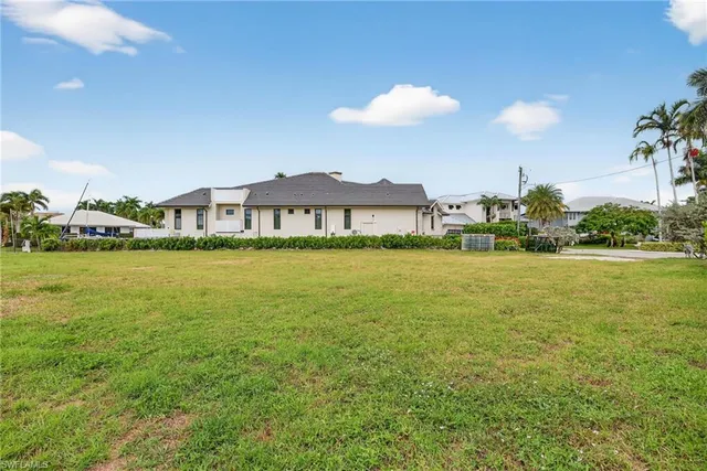 a view of a house with a yard and potted plants
