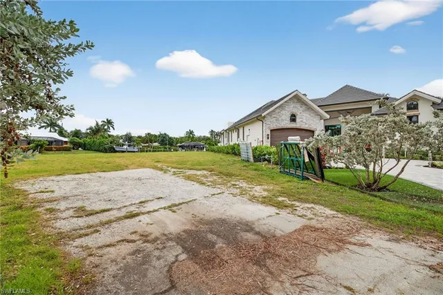 a view of a house with a yard and potted plants