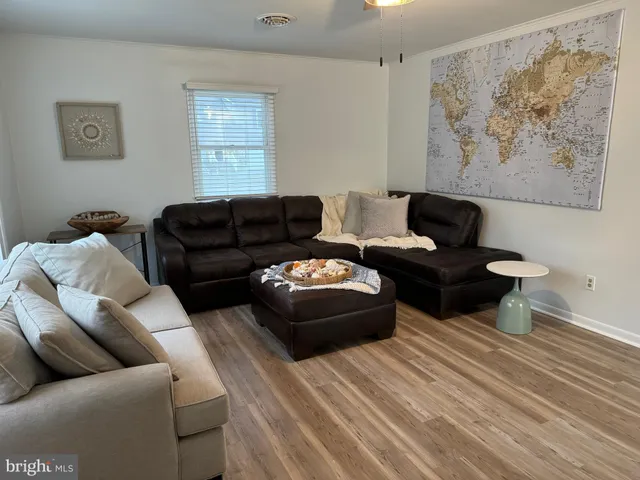 a living room with couches and a painting on the wall