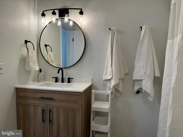 a bathroom with a sink vanity and a mirror