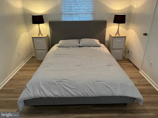 a bedroom with a bed and a flat tv screen on the dresser