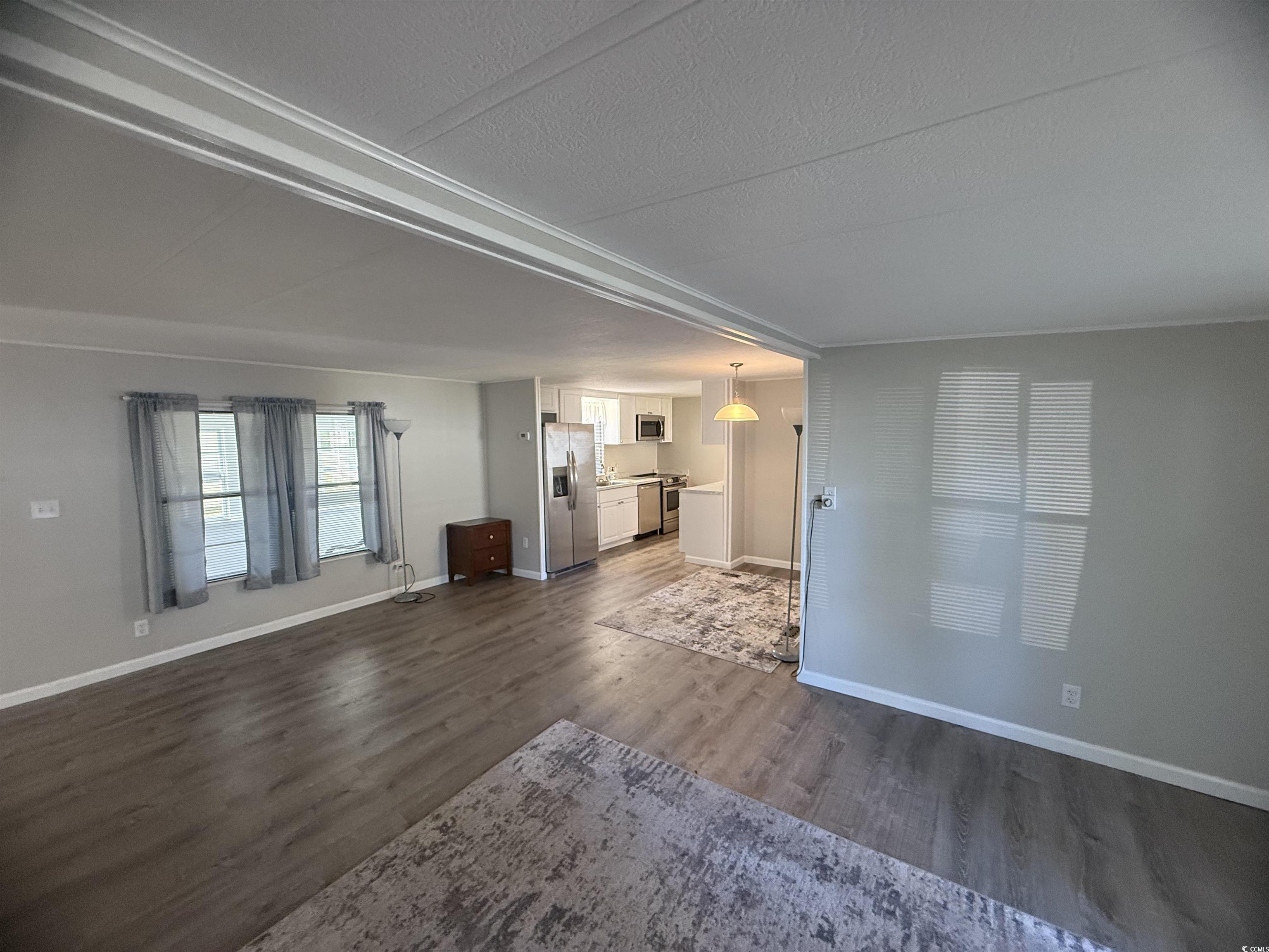 826 Jensen Drive North Murrells Inlet, SC 29576 - Photo 17 of 38 Unfurnished living room with dark wood-type flooring and a textured ceiling