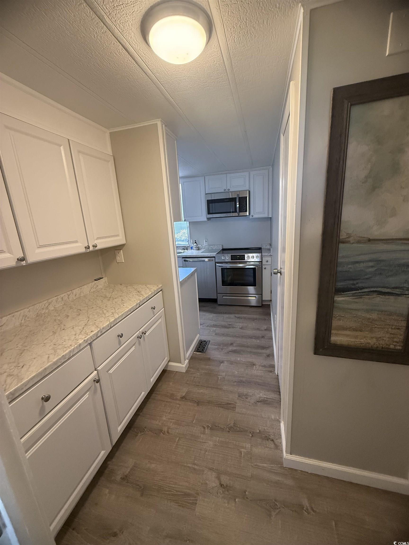 826 Jensen Drive North Murrells Inlet, SC 29576 - Photo 27 of 38 Hall with a textured ceiling and dark wood-style flooring